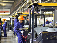 Workers assemble a cab at a loader manufacturing enterprise at Yunmenshan Street in Qingzhou, China, on October 31, 2024. On the same day, t...