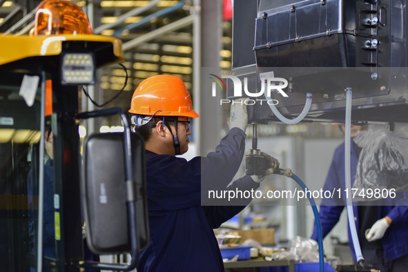 Workers assemble a cab at a loader manufacturing enterprise at Yunmenshan Street in Qingzhou, China, on October 31, 2024. On the same day, t...