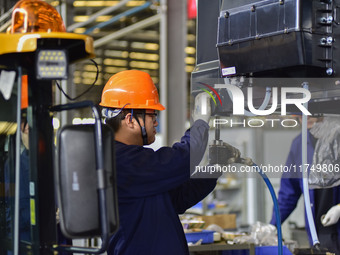 Workers assemble a cab at a loader manufacturing enterprise at Yunmenshan Street in Qingzhou, China, on October 31, 2024. On the same day, t...