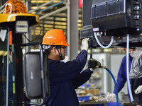 Workers assemble a cab at a loader manufacturing enterprise at Yunmenshan Street in Qingzhou, China, on October 31, 2024. On the same day, t...