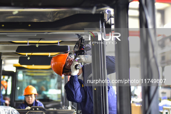 Workers assemble a cab at a loader manufacturing enterprise at Yunmenshan Street in Qingzhou, China, on October 31, 2024. On the same day, t...