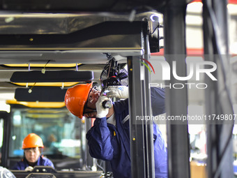 Workers assemble a cab at a loader manufacturing enterprise at Yunmenshan Street in Qingzhou, China, on October 31, 2024. On the same day, t...