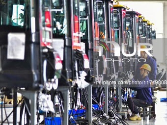 Workers assemble a cab at a loader manufacturing enterprise at Yunmenshan Street in Qingzhou, China, on October 31, 2024. On the same day, t...