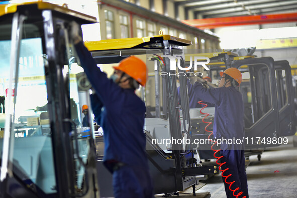 Workers assemble a cab at a loader manufacturing enterprise at Yunmenshan Street in Qingzhou, China, on October 31, 2024. On the same day, t...