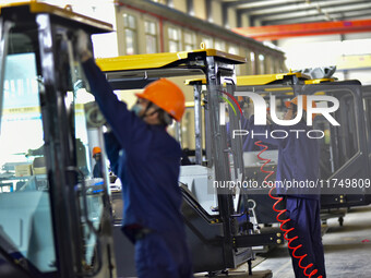 Workers assemble a cab at a loader manufacturing enterprise at Yunmenshan Street in Qingzhou, China, on October 31, 2024. On the same day, t...