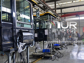 Workers assemble a cab at a loader manufacturing enterprise at Yunmenshan Street in Qingzhou, China, on October 31, 2024. On the same day, t...