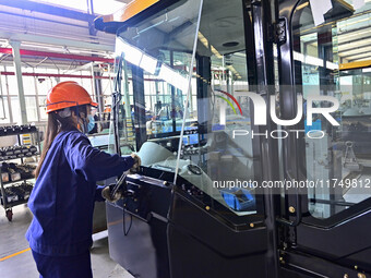 Workers assemble a cab at a loader manufacturing enterprise at Yunmenshan Street in Qingzhou, China, on October 31, 2024. On the same day, t...