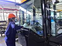 Workers assemble a cab at a loader manufacturing enterprise at Yunmenshan Street in Qingzhou, China, on October 31, 2024. On the same day, t...