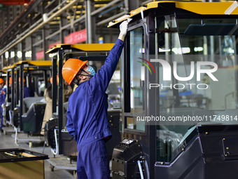 Workers assemble a cab at a loader manufacturing enterprise at Yunmenshan Street in Qingzhou, China, on October 31, 2024. On the same day, t...