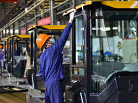 Workers assemble a cab at a loader manufacturing enterprise at Yunmenshan Street in Qingzhou, China, on October 31, 2024. On the same day, t...