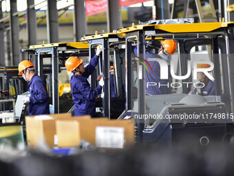 Workers assemble a cab at a loader manufacturing enterprise at Yunmenshan Street in Qingzhou, China, on October 31, 2024. On the same day, t...