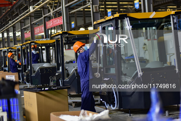 Workers assemble a cab at a loader manufacturing enterprise at Yunmenshan Street in Qingzhou, China, on October 31, 2024. On the same day, t...