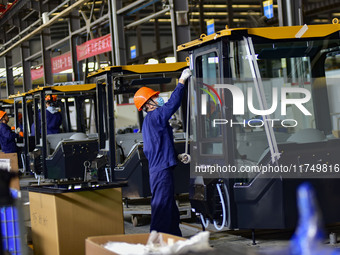 Workers assemble a cab at a loader manufacturing enterprise at Yunmenshan Street in Qingzhou, China, on October 31, 2024. On the same day, t...