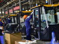 Workers assemble a cab at a loader manufacturing enterprise at Yunmenshan Street in Qingzhou, China, on October 31, 2024. On the same day, t...