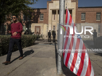 An Iranian man walks past the U.S. flag, which hangs upside down, while visiting the former U.S. embassy in Tehran, Iran, on November 7, 202...