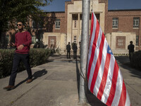 An Iranian man walks past the U.S. flag, which hangs upside down, while visiting the former U.S. embassy in Tehran, Iran, on November 7, 202...