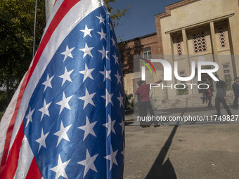 Two Iranian men take a selfie while standing next to the U.S. flag, which hangs upside down at the former U.S. embassy in Tehran, Iran, on N...