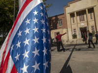 Two Iranian men take a selfie while standing next to the U.S. flag, which hangs upside down at the former U.S. embassy in Tehran, Iran, on N...