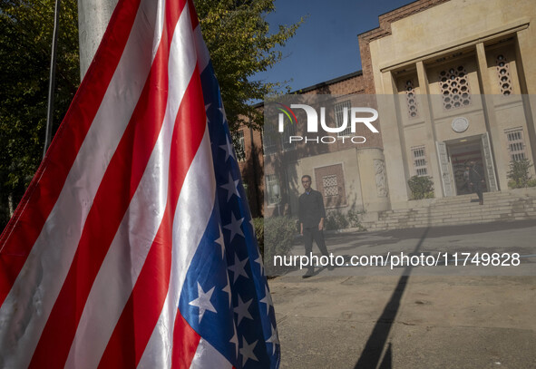 An Iranian man walks past the U.S. flag, which hangs upside down, while visiting the former U.S. embassy in Tehran, Iran, on November 7, 202...