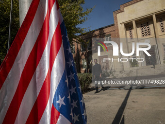 An Iranian man walks past the U.S. flag, which hangs upside down, while visiting the former U.S. embassy in Tehran, Iran, on November 7, 202...