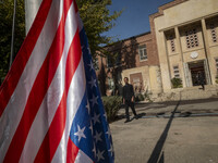 An Iranian man walks past the U.S. flag, which hangs upside down, while visiting the former U.S. embassy in Tehran, Iran, on November 7, 202...