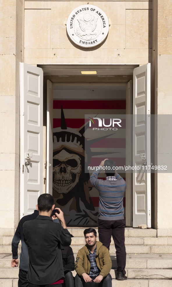 An Iranian man takes a selfie while his friend takes a photograph of an anti-U.S. mural at the former U.S. embassy in Tehran, Iran, on Novem...