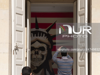 An Iranian man takes a selfie while his friend takes a photograph of an anti-U.S. mural at the former U.S. embassy in Tehran, Iran, on Novem...