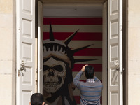 An Iranian man takes a selfie while his friend takes a photograph of an anti-U.S. mural at the former U.S. embassy in Tehran, Iran, on Novem...