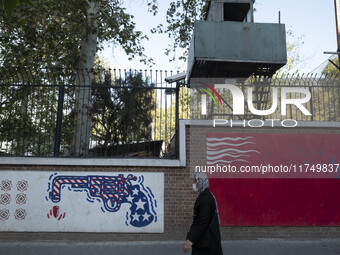 An Iranian woman walks past anti-U.S. murals on a wall of the former U.S. embassy in Tehran, Iran, on November 7, 2024. Former U.S. Presiden...