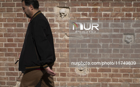 An Iranian man walks past anti-U.S. sculptures on a wall of the former U.S. embassy in Tehran, Iran, on November 7, 2024. Former U.S. Presid...