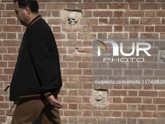 An Iranian man walks past anti-U.S. sculptures on a wall of the former U.S. embassy in Tehran, Iran, on November 7, 2024. Former U.S. Presid...