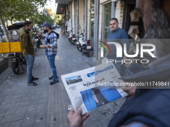 An Iranian man reads a newspaper with an image of the U.S. President-elect, Donald Trump, on its front page while standing on a sidewalk in...