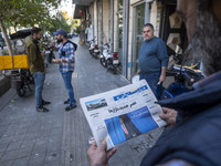 An Iranian man reads a newspaper with an image of the U.S. President-elect, Donald Trump, on its front page while standing on a sidewalk in...