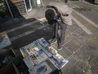 An elderly Iranian man reads newspapers with images of the U.S. President-elect, Donald Trump, on their front pages on a sidewalk in downtow...