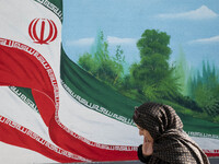 An Iranian woman walks past a mural featuring an Iranian flag in downtown Tehran, Iran, on November 7, 2024. Former U.S. President and Repub...