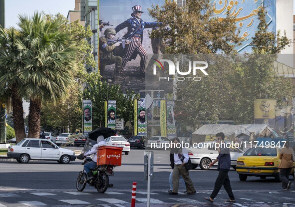 Iranian youths walk under an anti-U.S. and Israeli banner in downtown Tehran, Iran, on November 7, 2024. Former U.S. President and Republica...