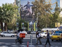 Iranian youths walk under an anti-U.S. and Israeli banner in downtown Tehran, Iran, on November 7, 2024. Former U.S. President and Republica...