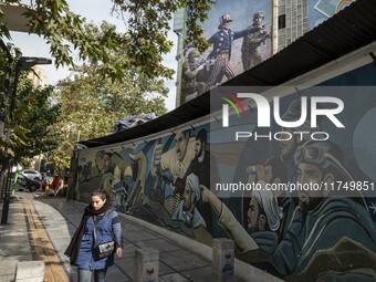 A young Iranian woman walks past an anti-U.S. banner and an anti-Israeli mural in downtown Tehran, Iran, on November 7, 2024. Former U.S. Pr...