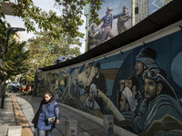 A young Iranian woman walks past an anti-U.S. banner and an anti-Israeli mural in downtown Tehran, Iran, on November 7, 2024. Former U.S. Pr...