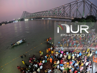 A Hindu devotee offers prayers to the sun god during the Chhath Festival at the Ganga ghat and the backside of Howrah Bridge in Kolkata, Ind...