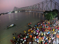 A Hindu devotee offers prayers to the sun god during the Chhath Festival at the Ganga ghat and the backside of Howrah Bridge in Kolkata, Ind...