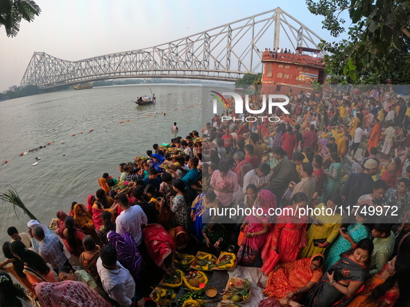 A Hindu devotee offers prayers to the sun god during the Chhath Festival at the Ganga ghat and the backside of Howrah Bridge in Kolkata, Ind...