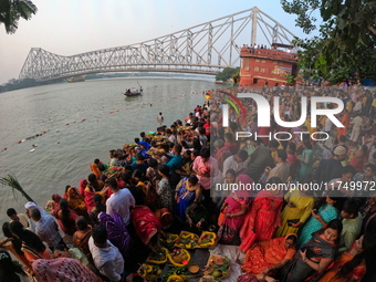 A Hindu devotee offers prayers to the sun god during the Chhath Festival at the Ganga ghat and the backside of Howrah Bridge in Kolkata, Ind...