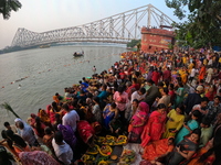 A Hindu devotee offers prayers to the sun god during the Chhath Festival at the Ganga ghat and the backside of Howrah Bridge in Kolkata, Ind...