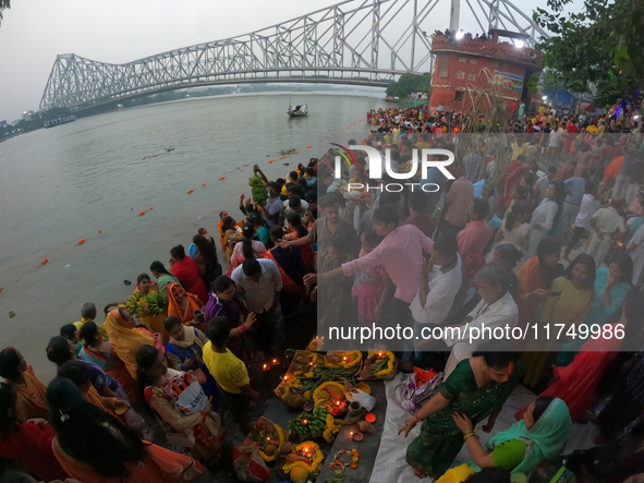 A Hindu devotee offers prayers to the sun god during the Chhath Festival at the Ganga ghat and the backside of Howrah Bridge in Kolkata, Ind...