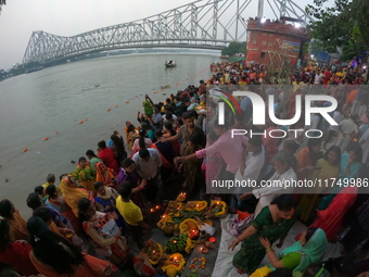 A Hindu devotee offers prayers to the sun god during the Chhath Festival at the Ganga ghat and the backside of Howrah Bridge in Kolkata, Ind...