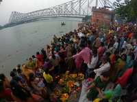 A Hindu devotee offers prayers to the sun god during the Chhath Festival at the Ganga ghat and the backside of Howrah Bridge in Kolkata, Ind...