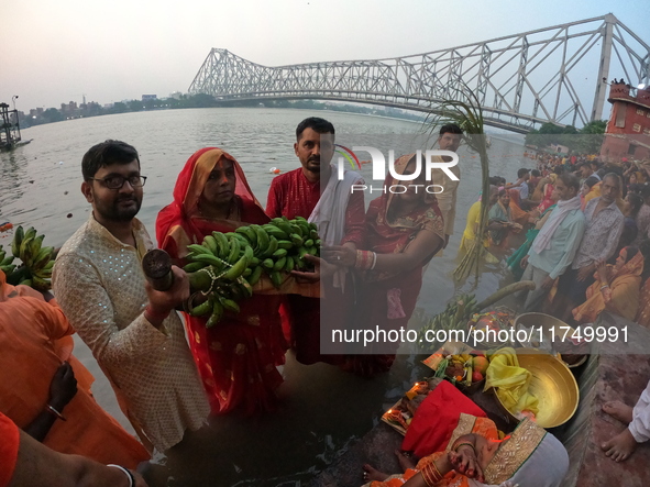 A Hindu devotee offers prayers to the sun god during the Chhath Festival at the Ganga ghat and the backside of Howrah Bridge in Kolkata, Ind...