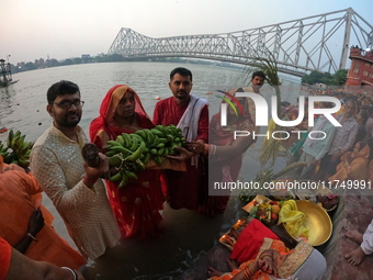 A Hindu devotee offers prayers to the sun god during the Chhath Festival at the Ganga ghat and the backside of Howrah Bridge in Kolkata, Ind...