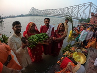 A Hindu devotee offers prayers to the sun god during the Chhath Festival at the Ganga ghat and the backside of Howrah Bridge in Kolkata, Ind...